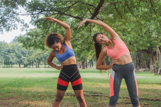 Mulheres de fitness praticando ioga em um parque. Mulheres fazendo exercícios de fitness em um parque.