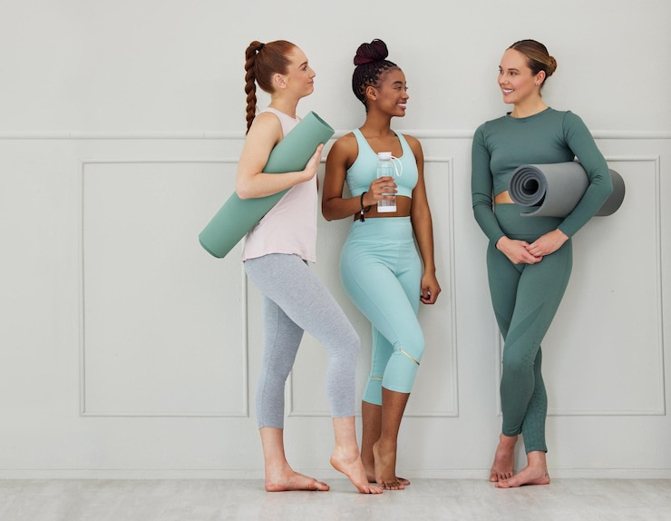 Foto mulheres de ioga e conversa com tapete de ginástica em wellness saúde e estúdio de pilates com amigos sorriso feliz e conversar com treinamento e fitness moda com garrafa e equipamentos de exercício com diversidade