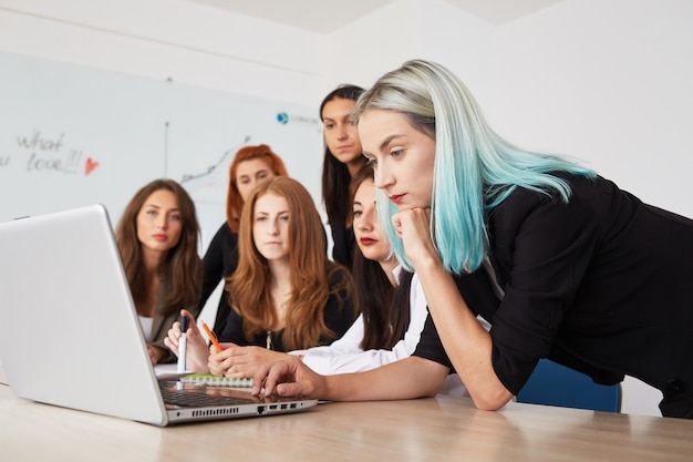 Mulheres de negócio de sorriso novas que trabalham o projeto novo no escritório.