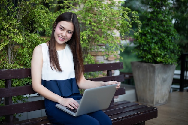 Mulheres de negócios asiáticos usando notebook para trabalhar no exterior