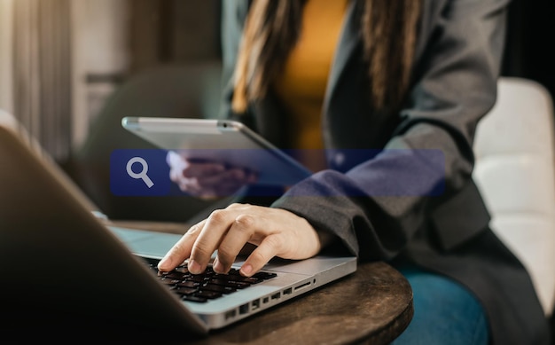 Mulheres de negócios clicando na página de pesquisa da internet na tela de toque do tablet e computador no escritório