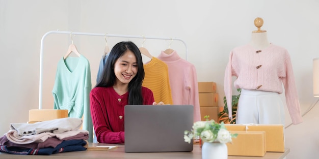 Mulheres de negócios de PME asiáticas usam laptop verificando caixas de envio on-line de pedidos de clientes em casa Iniciando Empreendedor de pequenas empresas SME freelance Negócios on-line Conceito de trabalho em casa