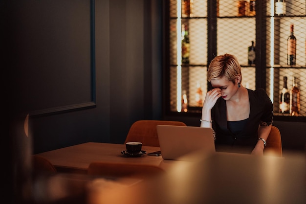 Mulheres de negócios estão estressadas enquanto trabalham no laptop Mulher de negócios cansada com dor de cabeça no café sentindo-se doente no trabalho Foco seletivo