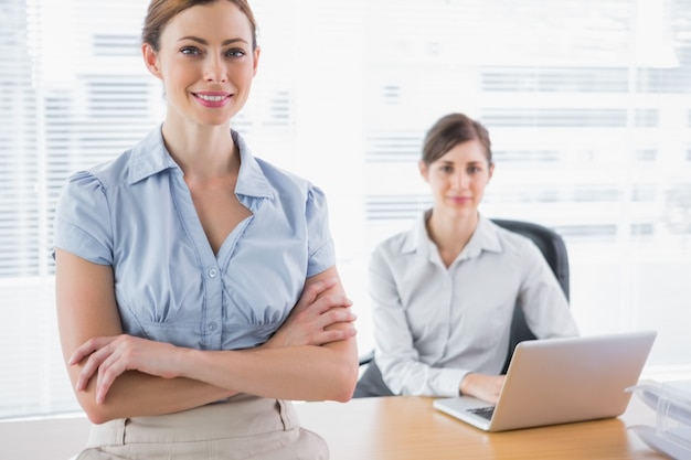 Mulheres de negócios felizes sorrindo para a câmera em sua mesa