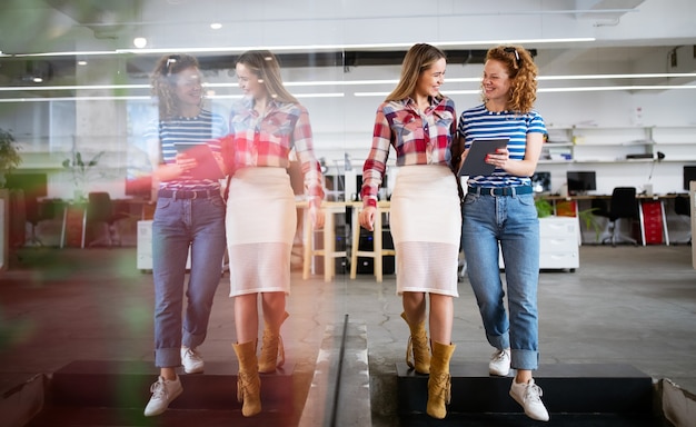 Mulheres de negócios sorridentes conversando e trabalhando juntas em um escritório bem iluminado