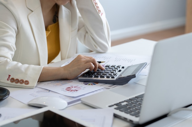 Mulheres de negócios usam calculadoras para calcular as despesas na mesa