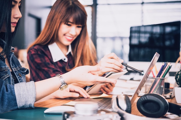 Mulheres de negócios usando laptop enquanto trabalham na secretária no escritório