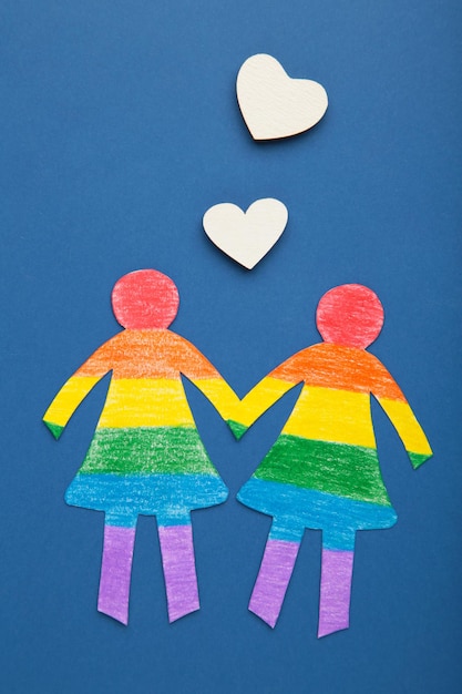Mulheres de papel cortadas de papel e pintadas em cores LGBT com corações brancos Conceito de LGBT em azul escuro Espaço para texto