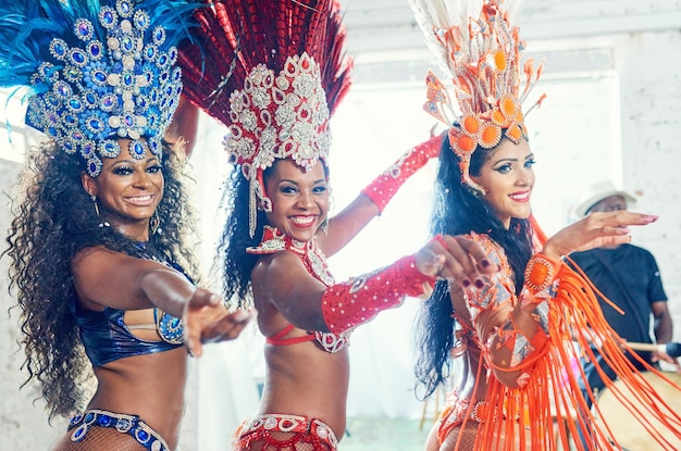 Mulheres de performance de carnaval e retrato de dançarina de mardi gras no ano novo dançando com um sorriso Grupo feminino de concerto em um evento de celebração social com música e show sexy, festa de dança e festival