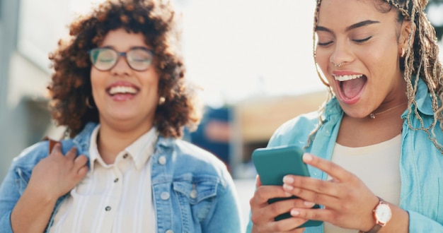 Foto mulheres de piadas e smartphones ao ar livre conversam e pesquisam navegando ou compartilham memes de mídia social em londres telefone e amigos rindo em uma cidade online para meme comic ou aplicativo em um ambiente urbano