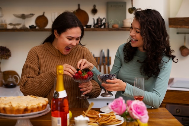 Mulheres de tiro médio com comida deliciosa