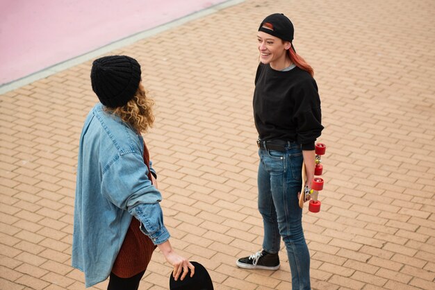 Mulheres de tiro médio segurando skates