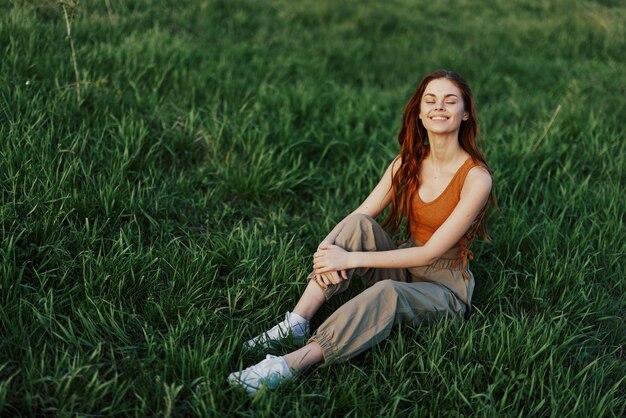 Mulheres de verão estilo de vida de férias no parque sentado na grama verde olhando para a câmera e sorrindo