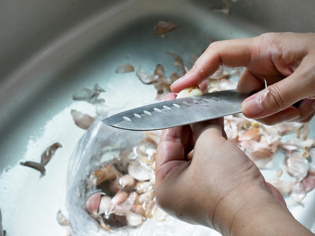 Mulheres descascam alho na cozinha.