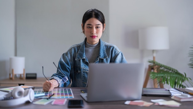 Mulheres designer gráfica trabalhando em tablet digital e laptop para projetar design gráfico de logotipo de marca