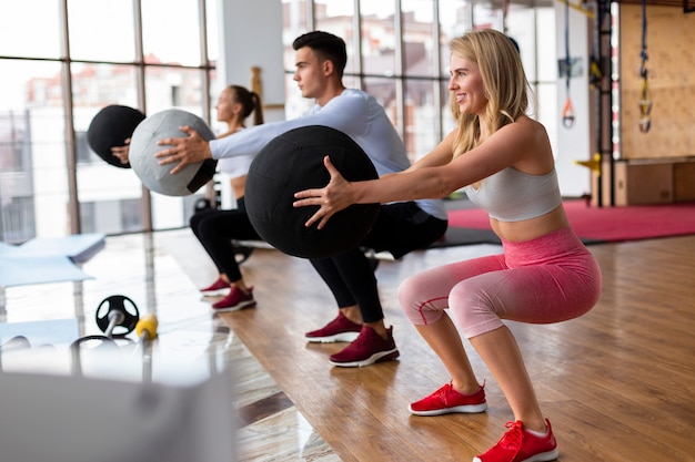 Mulheres e homem treinando na academia