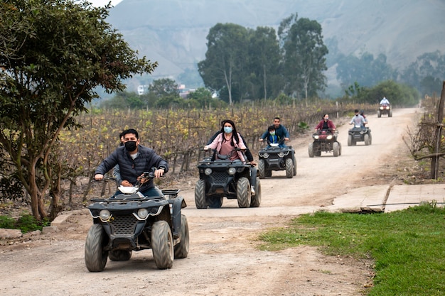 Mulheres e homens em ATVs estão curtindo um passeio no campo