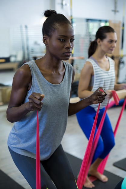 Mulheres em forma fazendo exercícios de alongamento com faixa de resistência