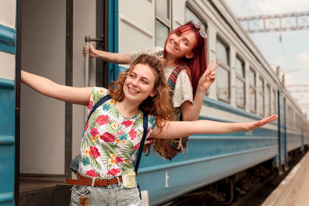 Foto mulheres em meio a tiro penduradas na porta do trem