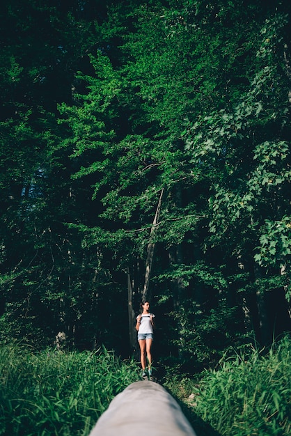 Mulheres em pé em um tronco de árvore na floresta