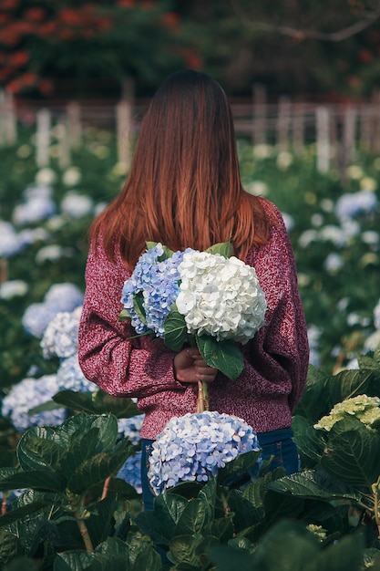 Mulheres em pé segurando flores de hortênsia