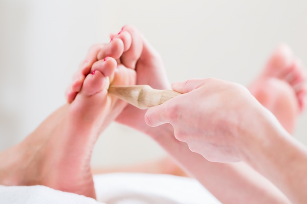 Mulheres em reflexologia com pé massageado
