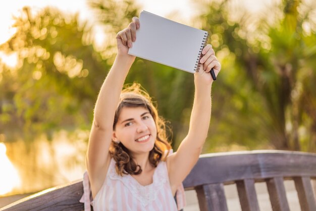 Mulheres em um fundo tropical segurando uma maquete de papel de placa