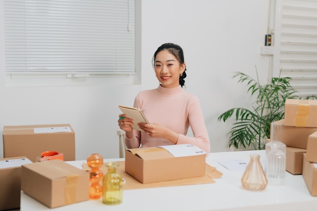 Mulheres embalando pacotes com seus produtos que ela vende online