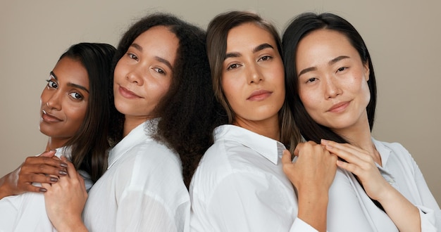 Mulheres enfrentam e cuidados com a pele grupo diversidade com apoio amoroso e amigos felizes em retrato para cosméticos em um fundo de estúdio jovens sorriem juntos e abraçam para dermatologia beleza e maquiagem