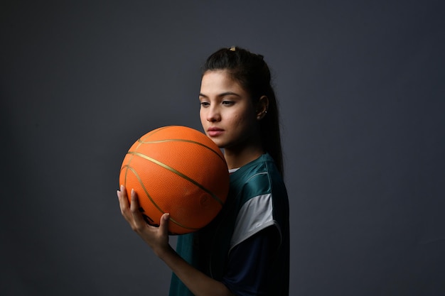 mulheres esportivas segurando basquete e olhando modelo paquistanês indiano