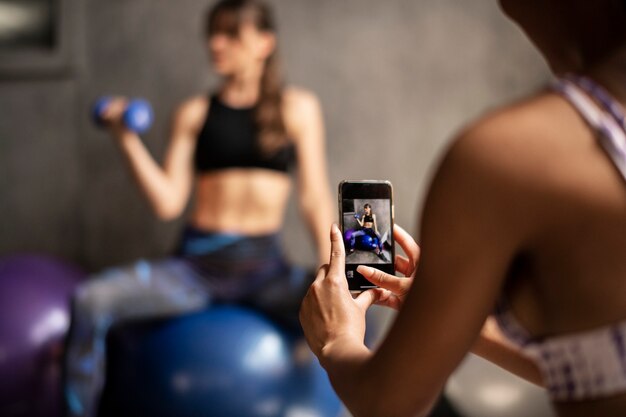 Foto mulheres esportivas tirando uma foto da amiga