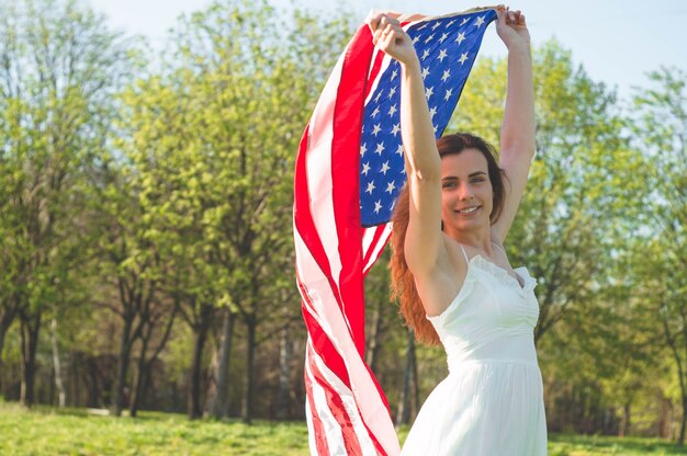 Mulheres felizes com a bandeira americana nos EUA comemoram 4 de julho