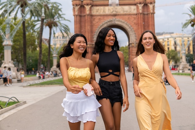 Mulheres felizes e multiétnicas em roupas da moda na cidade