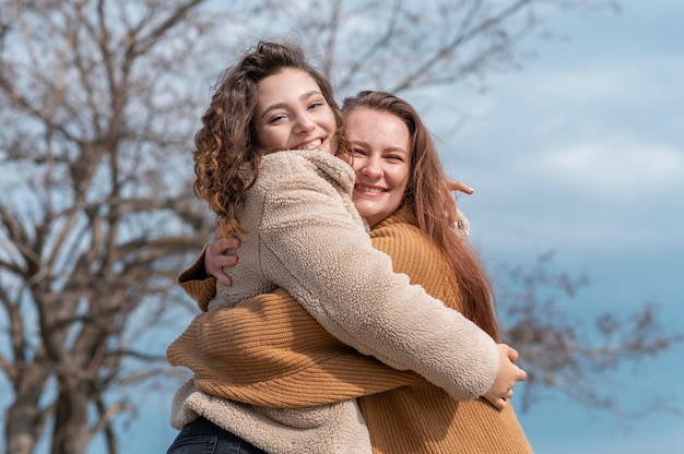 Mulheres felizes posando juntas ao ar livre