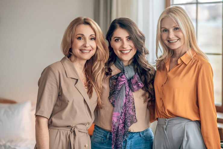 Foto mulheres felizes. três mulheres em trajes elegantes sorrindo e parecendo felizes