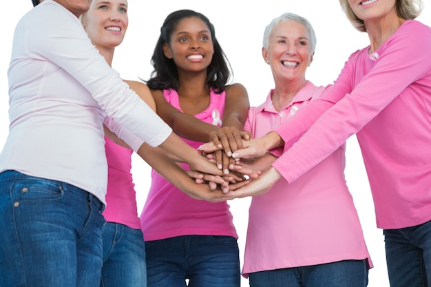 Foto mulheres felizes vestindo fitas de câncer de mama com as mãos juntas