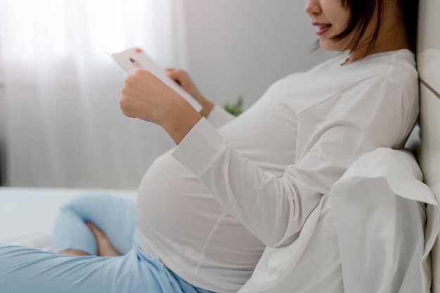 Mulheres grávidas asiáticas gostam de ler contos de fadas para crianças ainda não nascidas todas as manhãs e antes de dormir