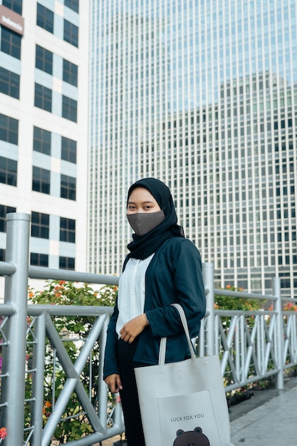 Foto mulheres hijab usando máscaras em áreas urbanas