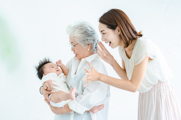 Mulheres idosas abraçando bebês e mulheres cuidando