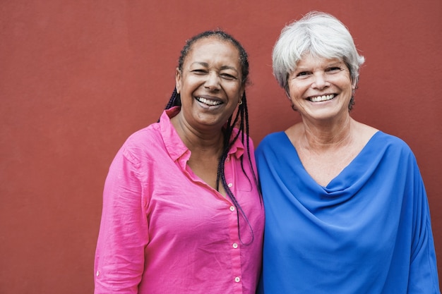 Foto mulheres idosas multirraciais olhando e sorrindo para a câmera - conceito de amizade de idosos