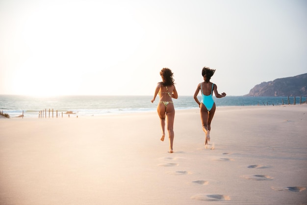 Mulheres irreconhecíveis curtindo na praia em traje de banho