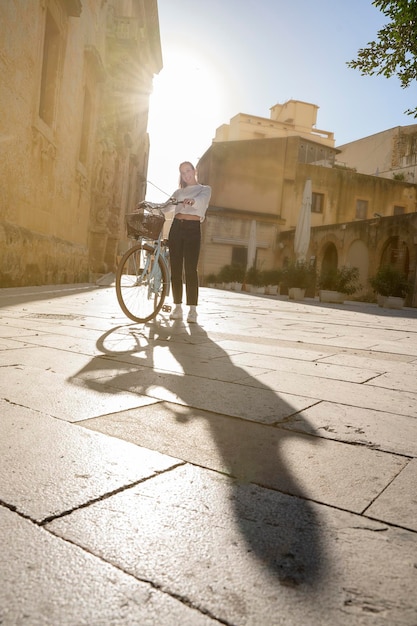 Foto mulheres jovens andando de bicicleta em um dia ensolarado em uma pausa na cidade