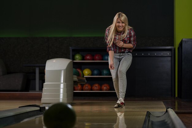 Mulheres jovens brincando com uma bola de boliche