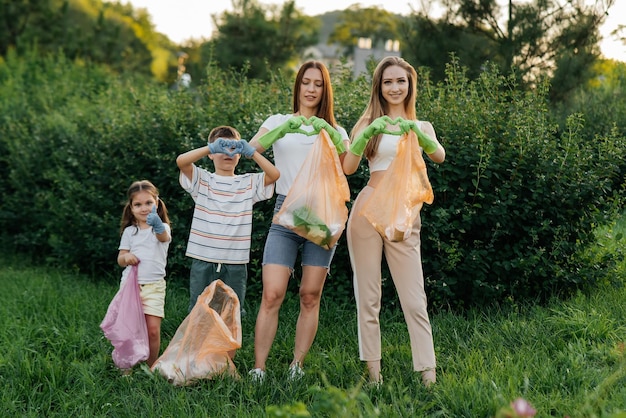 Mulheres jovens com bebês mostram corações depois de limpar lixo no parque durante o pôr do sol reciclagem de resíduos de cuidados ambientais separando lixo