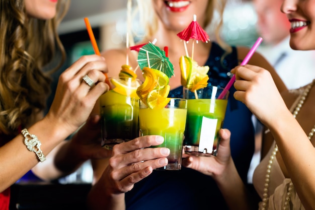 Mulheres jovens com cocktails no bar ou clube