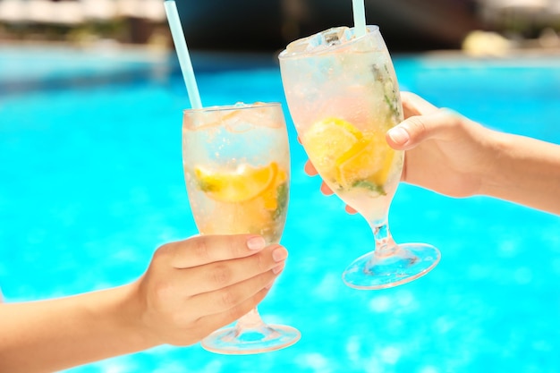 Foto mulheres jovens com copos de limonada perto da piscina