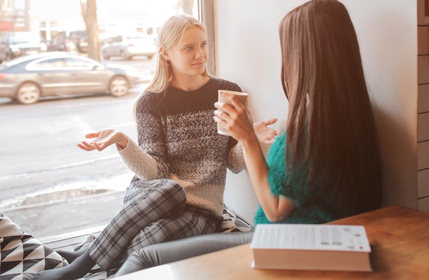 Mulheres jovens conversando em uma cafeteria