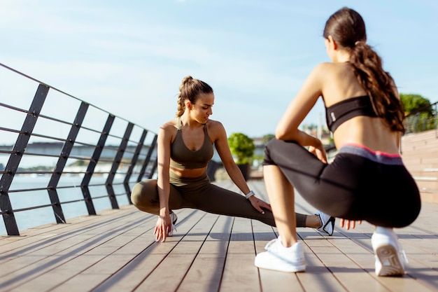 Mulheres jovens em roupas esportivas se exercitando em um passeio fluvial