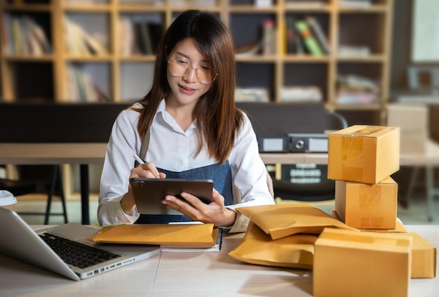 Mulheres jovens empreendedoras trabalhando em casa sobre negócios on-line Mulheres proprietárias de negócios usando tablet trabalhando em casa