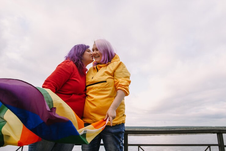 mulheres jovens felizes segurando a bandeira do orgulho lgbtq